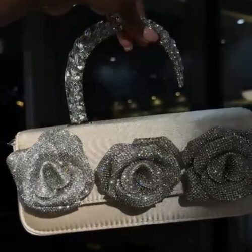 Rhinestone-embellished evening clutch bag with a rose floral design and a crystal top handle.