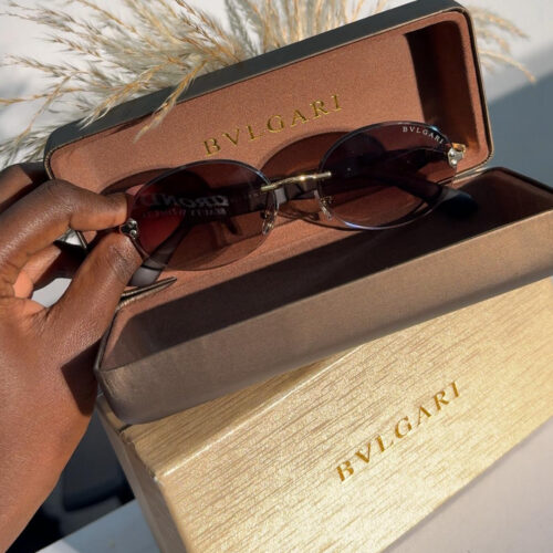Bvlgari oval sunglasses with a thin gold frame and brown gradient lenses.